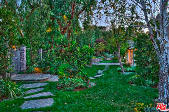 Зеленый сад с тропинкой во дворе дома Игги Азалии
