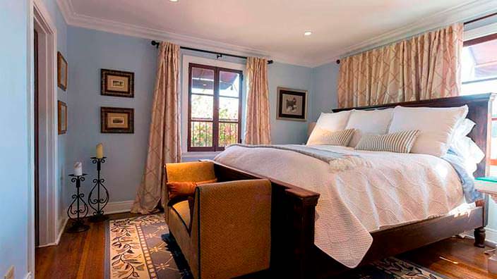 Высокая мягкая кровать в спальне в испанском стиле