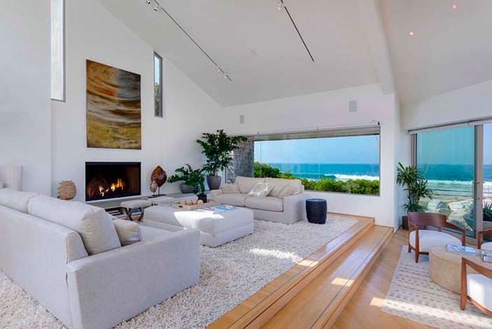 Современный дизайн гостиной с камином и видом на океан